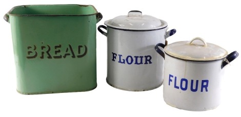 1920s enamel wares, comprising a green enamel flour bin, 29cm high, and two cylindrical flour bins in white and blue enamel, 26cm and 27cm high, each with lid. (3)