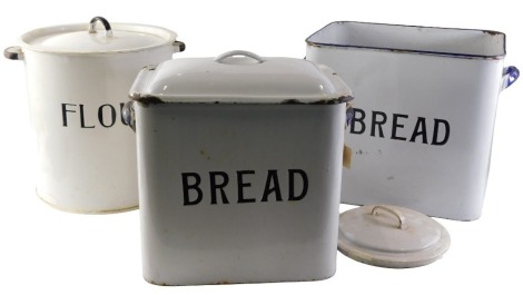 Two rectangular enamel bread bins, each on a white ground with blue border, with lids, 32cm and 31cm high, and a circular enamel flour bin, 31cm high, with lid. (3)