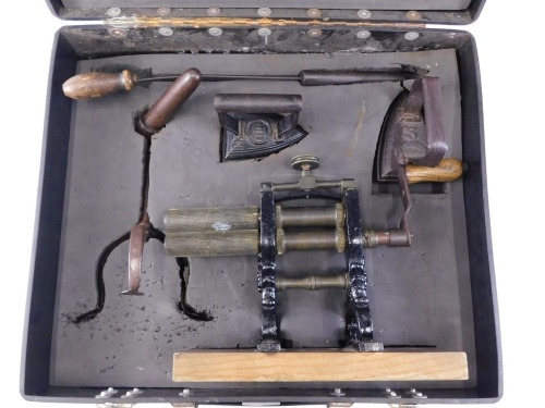A group of Victorian ironing equipment, comprising flat iron, smoothing iron, goffering iron, goffering iron stand, and a crimping machine, in flight case.