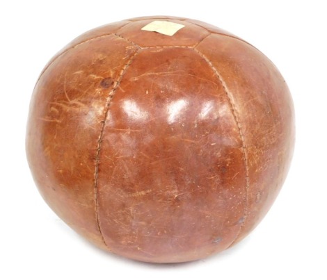 A 20thC leather patched medicine ball, 30cm high.