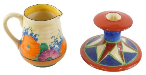 Two Bizarre by Clarice Cliff wares, comprising a candle stand, on a blue, green, red and cream ground, 8cm high, and a crocus pattern milk jug, 10cm high. (2)