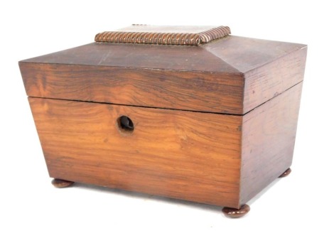 An early Victorian rosewood sarcophagus shaped tea caddy, the hinged lid enclosing two lidded divisions, on bun feet, 20cm wide.