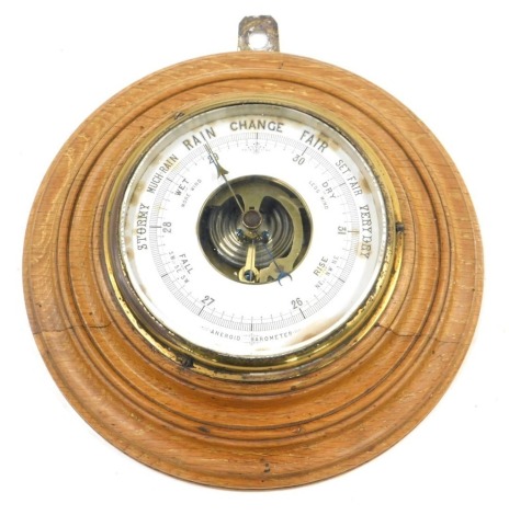 An early 20thC aneroid barometer, in circular moulded oak case, 42cm diameter.