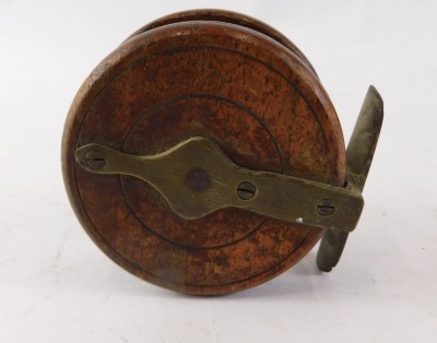 Three fishing reels, comprising a Nottingham style wooden reel, 7cm diameter, and two other reels, 6cm and 4cm diameter. (3) - 2