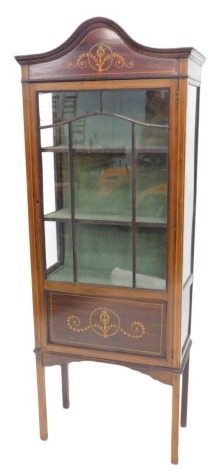 An Edwardian mahogany display cabinet, painted to simulate marquetry, with an arched top above a glazed door, on square section legs, 176cm high, 66cm wide.