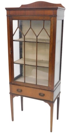 An early 20thC mahogany display cabinet, with a raised back, single glazed door and a drawer, on square tapering legs, 152cm high, 60cm wide.