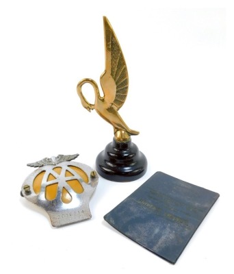 Car mascots and badges, comprising a 1930s Dailmer car mascot, in the Art Deco style, shaped swan on ebonised socle, 23cm high, AA car badge and a Motor Car badge 1983 booklet. (3)