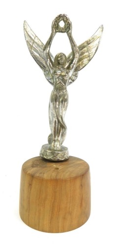 An early 20thC chrome car mascot, modelled as a winged lady with arms raised holding laurel leaf garland, on wooden base, 22cm high.