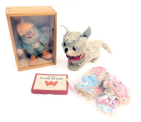 Toys and games, comprising a dwarf felt model in pine display case, a Merry Thoughts style grey cat, Three Little Pig jigsaw, and a Lotts stone puzzle of a butterfly. (1 shelf)