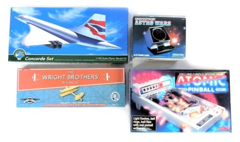 Models and games, comprising The Wright Brothers bi-plane kit, 1:144 scale Concorde Set, Grand Stand Astro Wars and Tomy Atomic Flipper. (4)