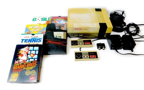 A Nintendo Entertainment System (NES), including accessories and games, including Super Mario Brothers, Super Spike Ball, Air Wolf, Metal Gear, Four Player Tennis, Nintendo World Cup, Goal, etc. (1 box)