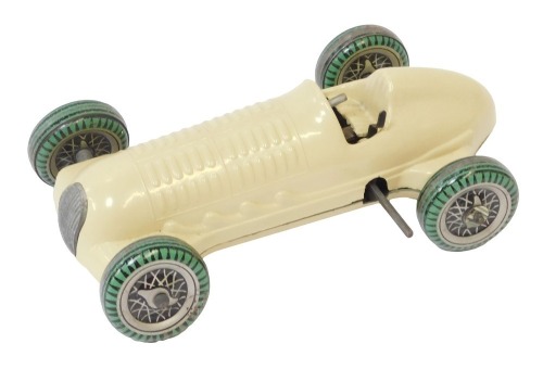 A Mettoy clockwork tinplate racing car, on a cream ground with black and green spoked tyres and winding point, no key.