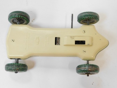 A Mettoy clockwork tinplate racing car, on a cream ground with black and green spoked tyres and winding point, no key. - 2