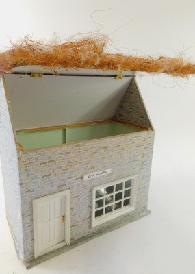 A wooden kit built doll's house, with a thatched roof, with applied brick detail, and various Christmas figures entitled Elf House, 49cm high, 38cm wide, 20cm deep. (AF) - 2