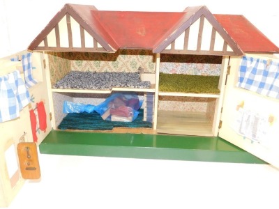 A Tri-ang wooden two storey doll's house, with red painted roof and bay windows, on a green painted rectangular base, 46cm high, 67.5cm wide, 27cm deep. - 2