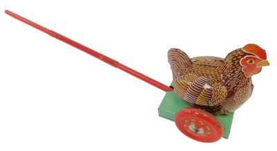 A 1960s tinplate pull along hen with rod.