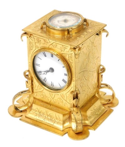 A Victorian brass cased desk clock, of Gothic form, with circular dial bearing Roman numerals, the top with a compensated barometer, the case of Gothic form, with engraved foliate decoration, 14cm high, 12.5cm wide,