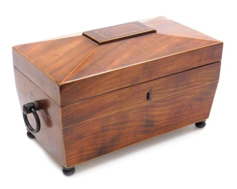 A Regency mahogany and rosewood tea caddy, with boxwood line inlay of sarcophagus form, with twin ring handle, the hinged lid opening to reveal two compartments flanking a recess for a mixing bowl, raised on turned feet, 34.5cm wide. (AF)