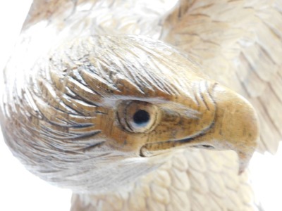 A wooden carved figure of an eagle, its wings aloft, raised on a naturalistic base, 78cm high. - 2