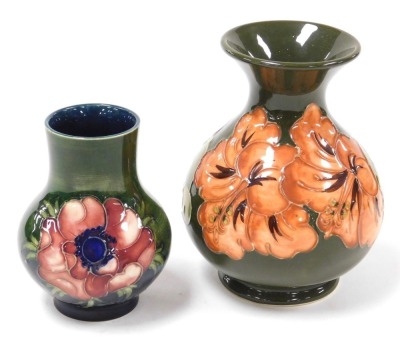 A Moorcroft pottery Anemone pattern vase, of baluster form, green ground, bears paper label, 10cm high, together with a Hibiscus pattern vase, of baluster form, green ground, impressed marks, 13cm high. (2) - 2