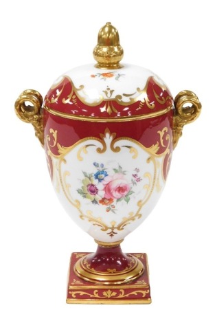 An early 20thC Wedgwood porcelain twin handled vase and cover, of footed ovoid form, with twin gilt satyr handles, the body painted with reserves of flowers, gilt heightened, against a burgundy ground, pattern Z2977, printed and painted marks, 21cm high. 