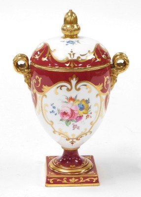 An early 20thC Wedgwood porcelain twin handled vase and cover, of footed ovoid form, with twin gilt satyr handles, the body painted with reserves of flowers, gilt heightened, against a burgundy ground, pattern Z2977, printed and painted marks, 21cm high. - 3