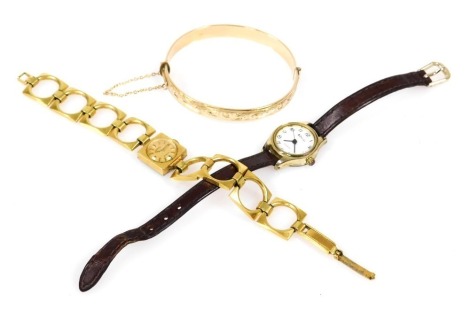 A 9ct gold plated bangle, foliate engraved, on a snap clasp, with safety chain as fitted, together with a Roamer, and a Ravel lady's dress wristwatch. (3)