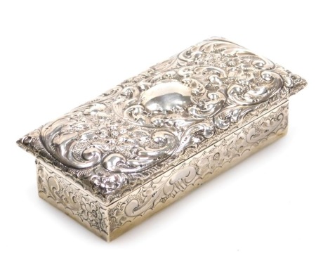 An Edward VII silver dressing table box, with embossed floral and foliate scroll decoration, vacant central reserve, Birmingham 1902, 4.88oz, 12.5cm wide.