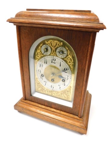 An early 20thC oak cased mantel clock, domed brass dial with foliate spandrels, circular silver chapter ring bearing Arabic numerals, subsidiary slow fast and chime silent dial, eight day movement with Westminster chimes, the case of domed plain form, rai