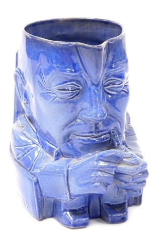 An early 20thC Ashstead pottery character jug of Stanley Baldwin, Prime Minister, limited edition 977/1000, blue glaze designed by Sir Percy Metcalfe, printed marks, 19.5cm high.