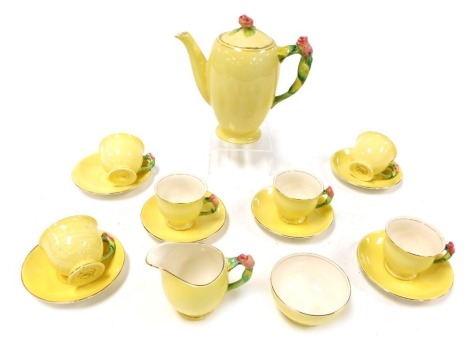 An early 20thC Royal Winton pottery part coffee service, yellow ground, with rose moulded handles and knop, printed marks, comprising coffee pot, cream jug, sugar bowl, six cups and saucers.