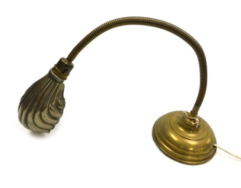 An early 20thC brass anglepoise desk lamp, with a fluted shell shaped shade, on a loaded base. Buyer Note: WARNING! This lot contains untested or unsafe electrical items. It is supplied for scrap or reconditioning only. TRADE ONLY