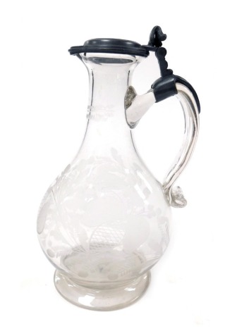 A 19thC cut glass flagon, with a hinged pewter lid, of pear shaped form, engraved with stylised flowers and leaves, 23cm high.