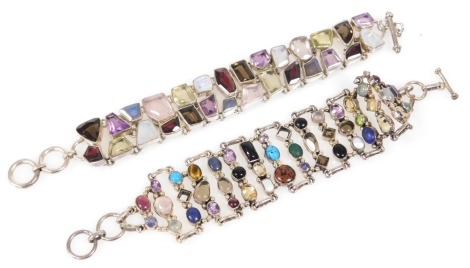 A two strand multi stone bracelet, set in white metal, with a double loop and t-bar clasp, and a further bracelet similarly designed with multi coloured gemstones. (2)(A)