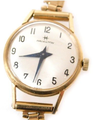 A Hamilton lady's 9ct gold case wristwatch, circular silver dial bearing Arabic numerals, on a 9ct gold strap, with safety chain as fitted, 13.5g all in.