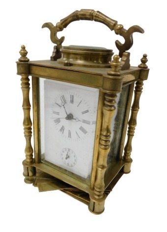 A late Victorian brass cased alarm carriage clock, rectangular white enamel dial bearing Roman numerals, subsidiary alarm dial, the movement with bell strike, case of conventional form with turned pilasters, 17cm high. (AF)