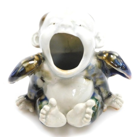 A Meiji period Japanese Hirado ware porcelain hand brazier, modelled as a winged, seated boy, his mouth agape, impressed gourd shaped seal, 10cm high.