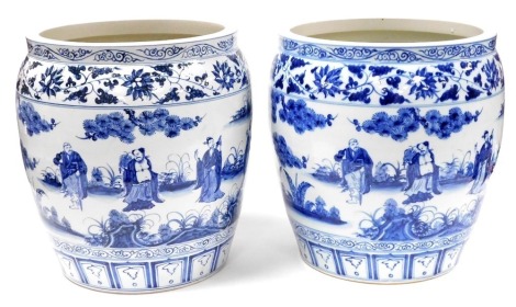 A pair of Chinese blue and white jardineres, each decorated with figures within leaf and flower borders, 43cm high, 38cm diameter.