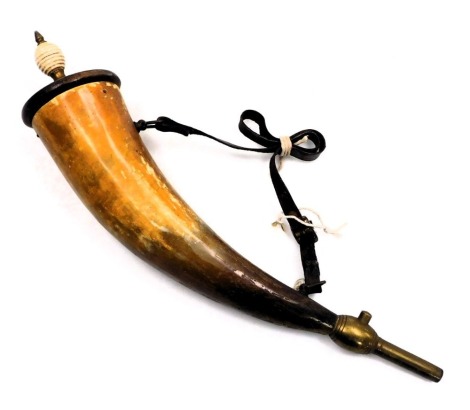 A 19thC horn powder flask, with a wooden cover and ceramic finial, with brass spout and spring operated cut off, leather carrying strap, 40.5cm long.