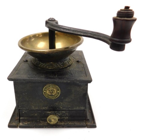 A Victorian cast iron and brass coffee grinder, with a frieze drawer and circular plaque marked manufacturers Wolverhampton, 23cm wide.