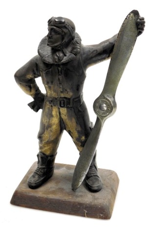 A 1930s silver plated aviator lighter, modelled as a pilot holding a propeller, on an oak base, 27cm high.