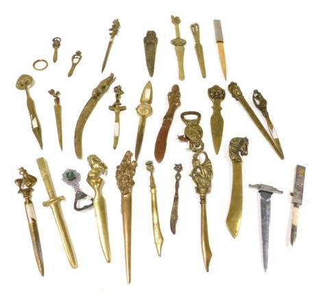 A group of Victorian and later copper and brass paper knives, with variously decorated terminals. (qty)