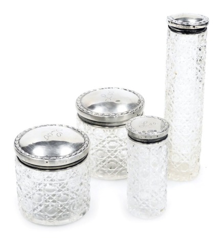 Four Edward VII cut glass and silver lidded dressing table jars, engraved Lou, Birmingham 1908 and Chester 1909, 1.51oz.