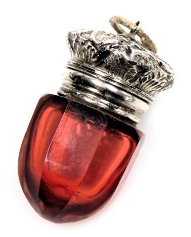 A Victorian cranberry glass vinaigrette with a hinged lid, and pierced grill, embossed with leaves and scrolls, with ring suspension, 4cm high.