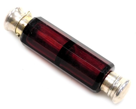 A Victorian cranberry glass double ended scent bottle, with a button operated hinged lid and a screw lid, of plain white metal form, 13.5cm wide. (AF)