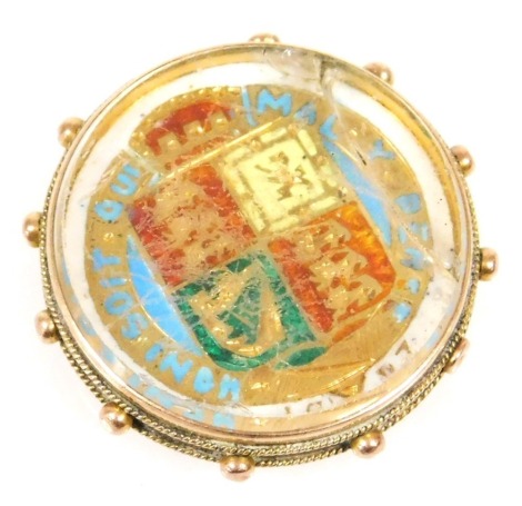 A Queen Victoria jubilee head coin 1887 with shield back, enamel inlaid, in a 9ct gold and glass backed circular frame, 10.1g all in.