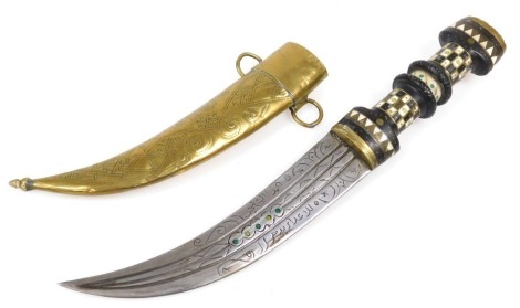 A 20thC Syrian Magdali dagger with a brass capped and inlaid ebony hilt, curved double edge blade and brass scabbard, 36cm long.