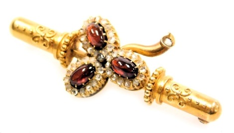 A Victorian Etruscan style red cabochon and diamond set bar brooch, of three leaf form, yellow metal, stamped AO to the pin, 7.8g all in.