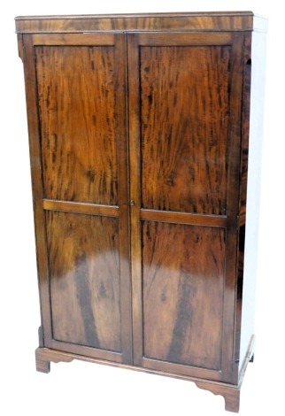 A mahogany wardrobe in George III style, with two panelled doors, on bracket feet, 179cm high, 108cm wide.