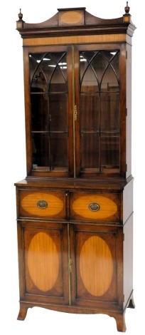 A mahogany and satinwood secretaire bookcase in George III style, the top with a shaped cornice and turned finials above two astragal glazed doors, enclosing adjustment shelves, the base with a fitted drawer with green tooled leather inset, above two pane